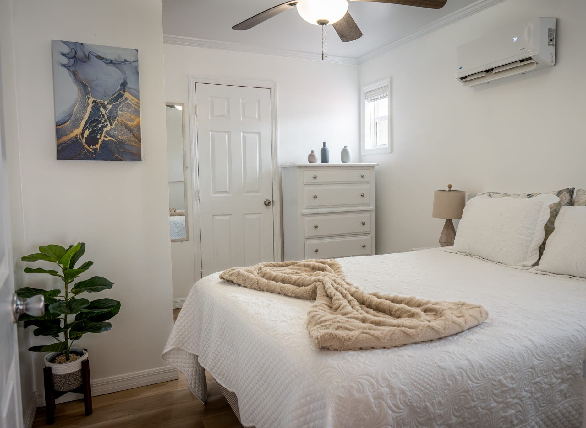 Bedroom of Boho Paradise with a white bed and a knitted throw
