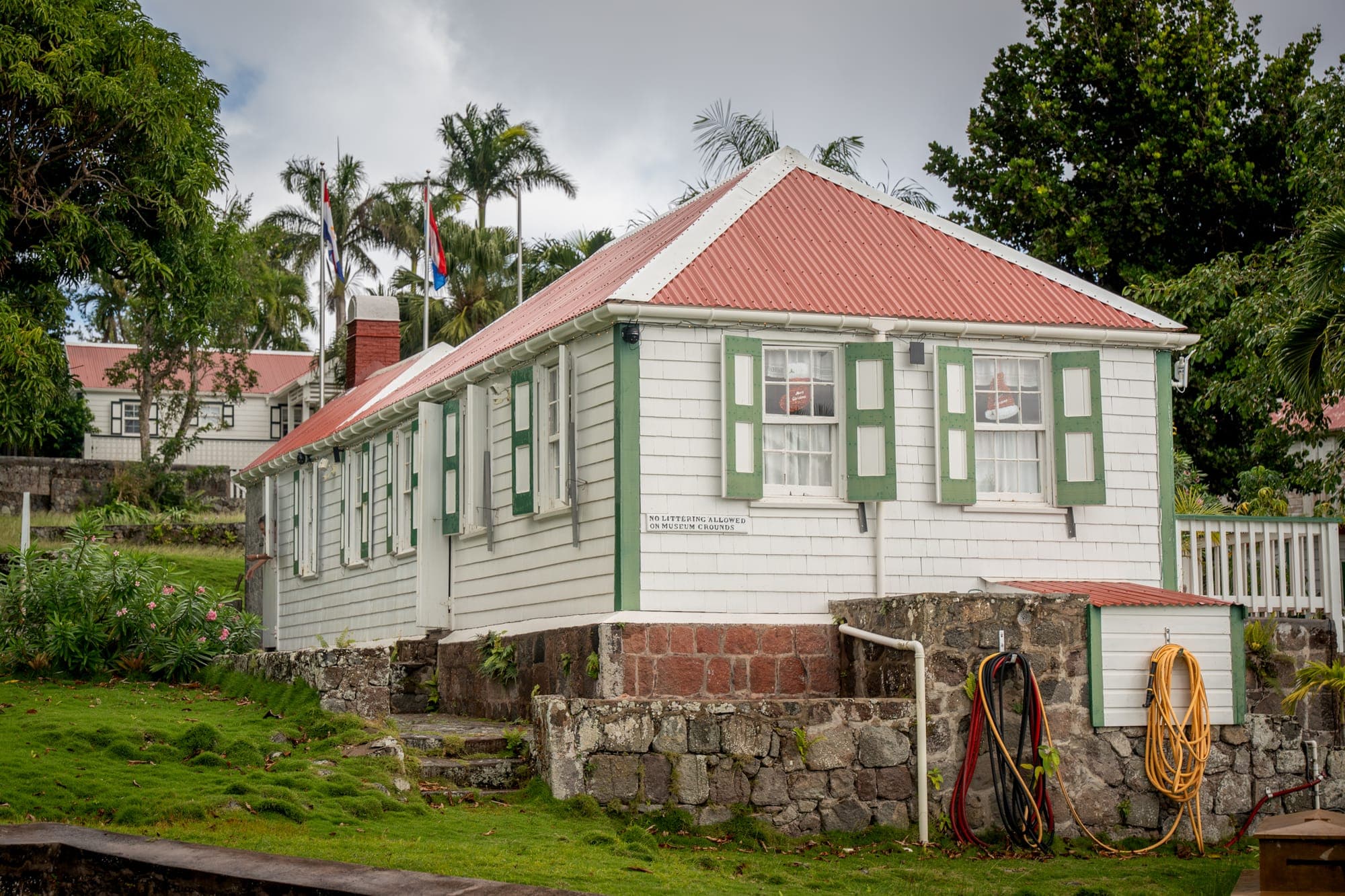 A traditional Saba cottage with a red roof and green shutters