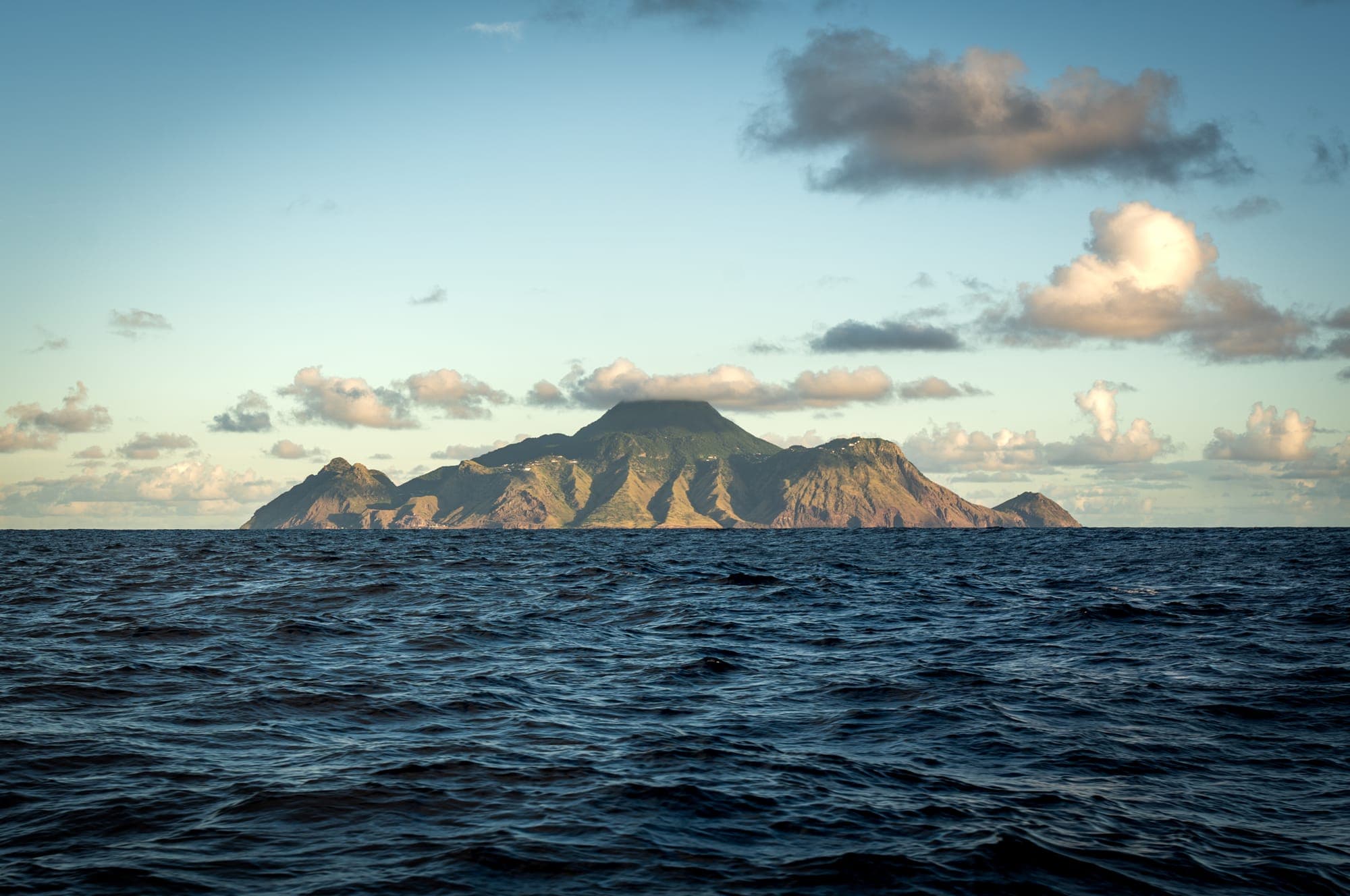 Saba rising from the ocean, seen from a boat
