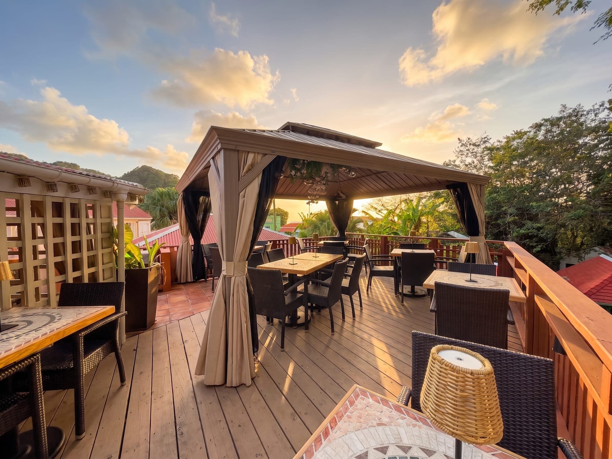 The terrace gazebo under a sunset sky, tables set for dinner