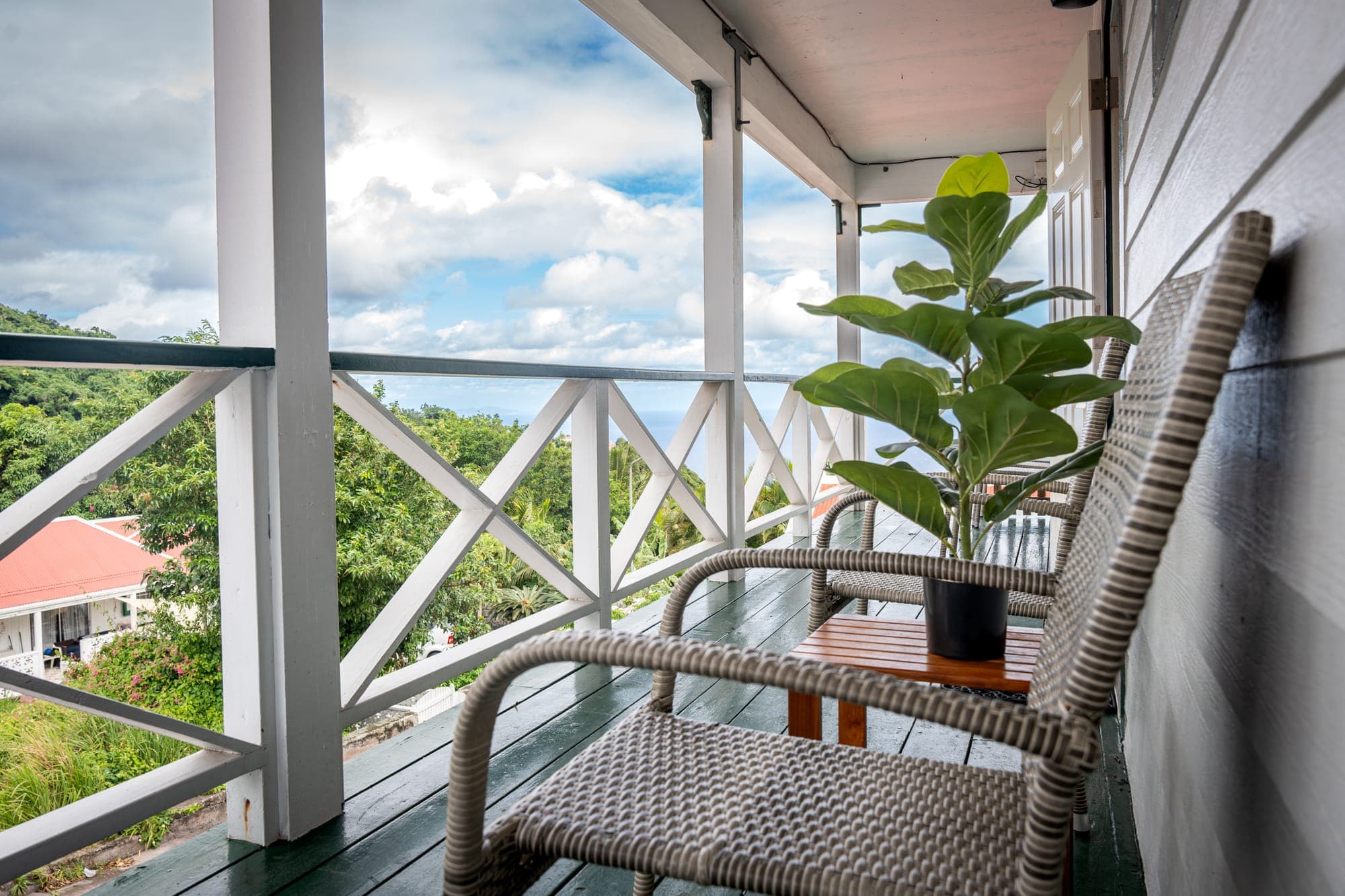 Veranda van Tropical Paradise met een schommelstoel en uitzicht over de helling